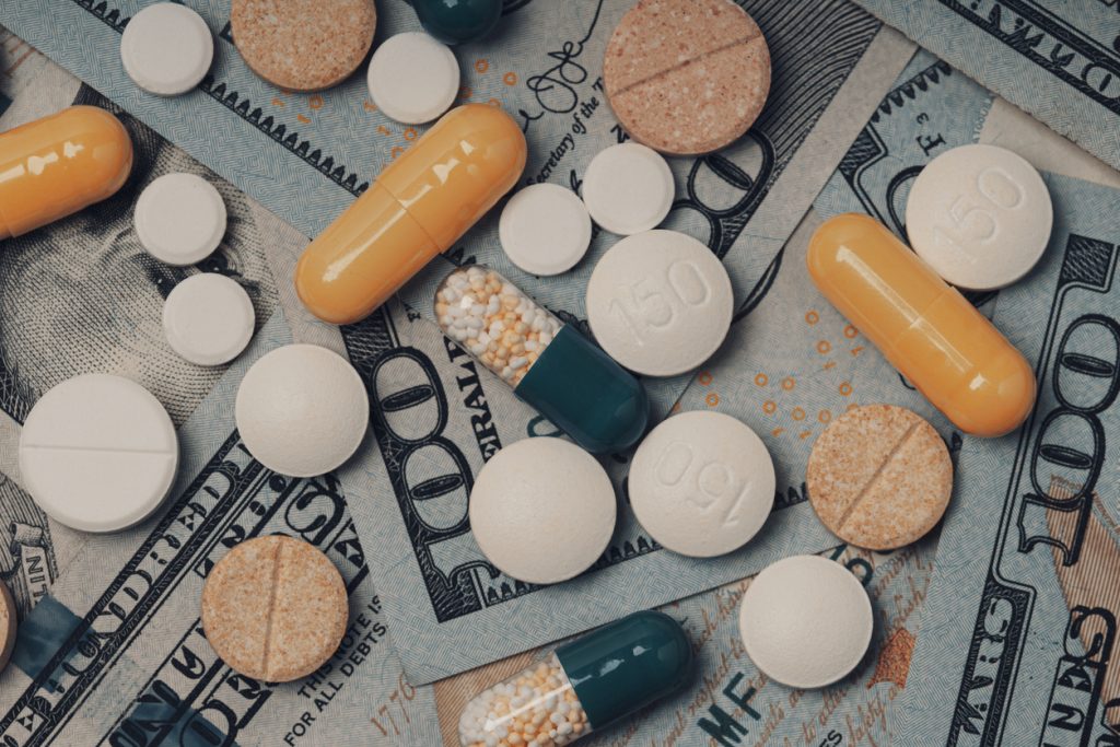 cost medicinal product and treatment concept. Different colorful pills capsules on money bills
